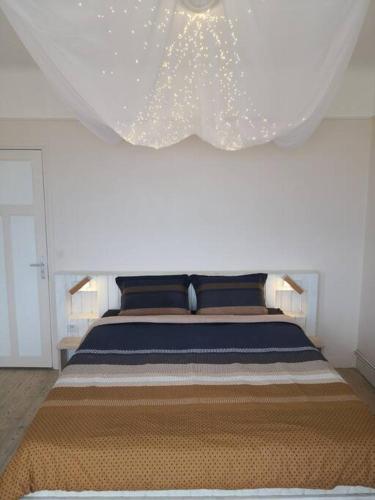 - une chambre avec un grand lit et un rideau au-dessus dans l'établissement Spa privatif face mer Riva Romantic & SPA, à Ouistreham