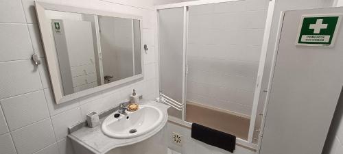 a white bathroom with a sink and a mirror at FFoz_Spot in Buarcos