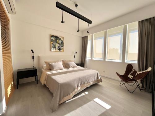- une chambre avec un lit, une chaise et des fenêtres dans l'établissement Premium apartament Distrito Quartier 1 br Retiro, à Buenos Aires