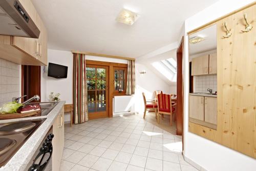 a kitchen with a sink and a dining room at Hotel Alpspitz B&B in Grainau