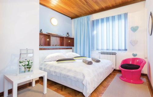a bedroom with a white bed and a pink chair at Rooms Croatia with parking, kitchen and dining area for guests in Rijeka