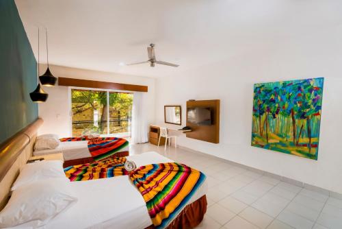 1 dormitorio con 2 camas y un cuadro en la pared en Hotel Mariachi by Kavia 5th Av en Playa del Carmen