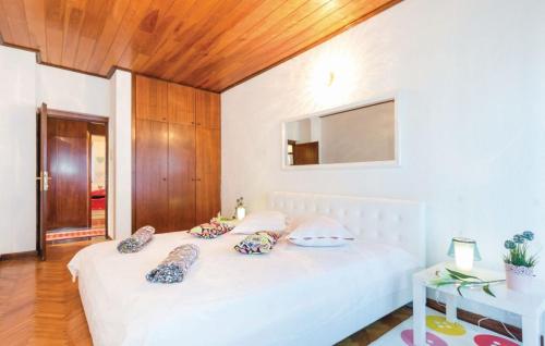 a bedroom with a white bed with pillows on it at Rooms Croatia with parking, kitchen and dining area for guests in Rijeka