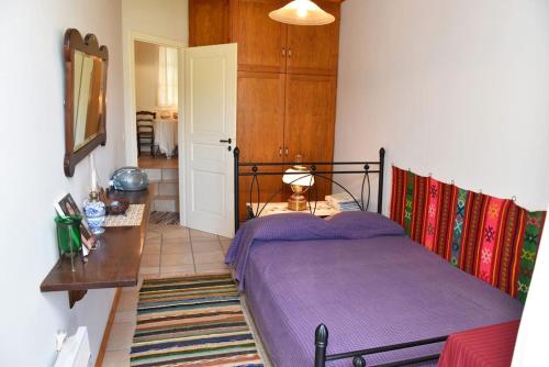 a bedroom with a bed and a table and a mirror at Panos House Andros in Andros
