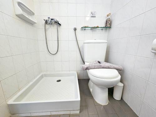 a white bathroom with a toilet and a bath tub at Studio Popi in Marathokampos
