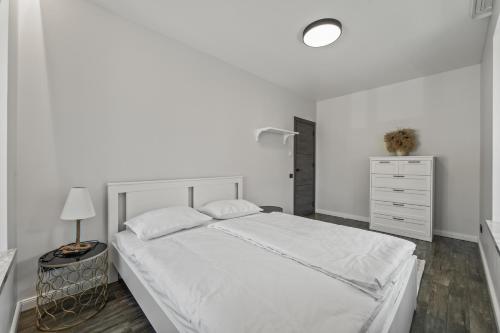 Dormitorio blanco con cama blanca y vestidor en Gailė, en Klaipėda