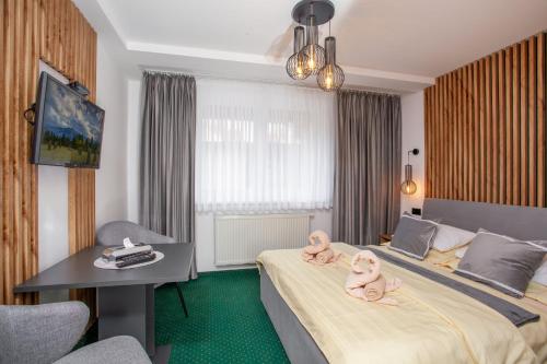 ein Hotelzimmer mit zwei ausgestopften Tieren auf einem Bett in der Unterkunft Penzión Blanka in Ždiar
