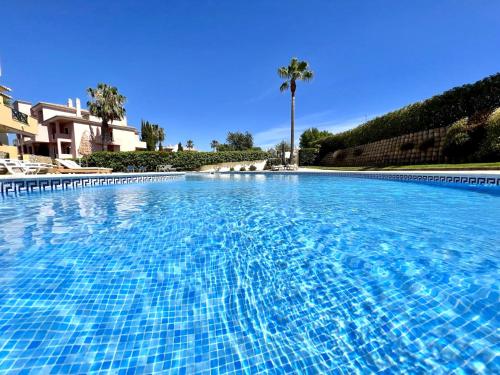 a large blue swimming pool with palm trees in the background at Albufeira Valley 2 With Pool by Homing in Albufeira