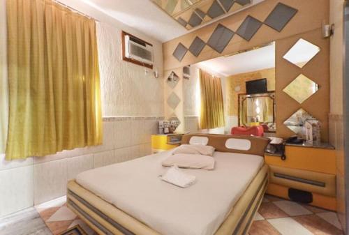 um quarto com uma cama grande e um espelho em Shelton Hotel no Rio de Janeiro