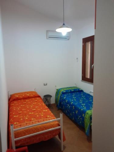 Un dormitorio con 2 camas y una silla. en Villa su due livelli super accessoriata en SantʼAnna Arresi
