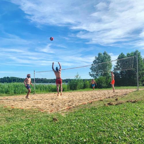 a group of people playing a game of volleyball at Lake House in Anykščiai