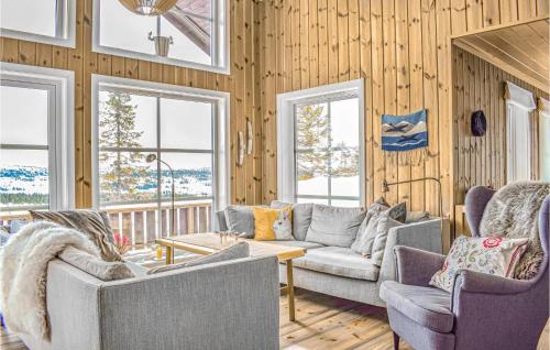 ein Wohnzimmer mit Stühlen, einem Sofa und Fenstern in der Unterkunft 4 Bedroom Cozy Home In Sjusjøen in Sjusjøen