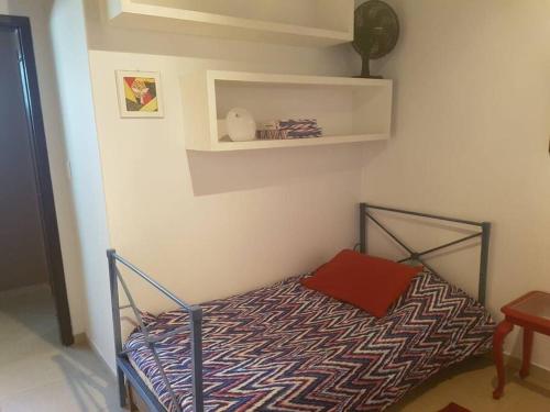 um pequeno quarto com uma cama num quarto em Casa ampla no Laranjal em Pelotas