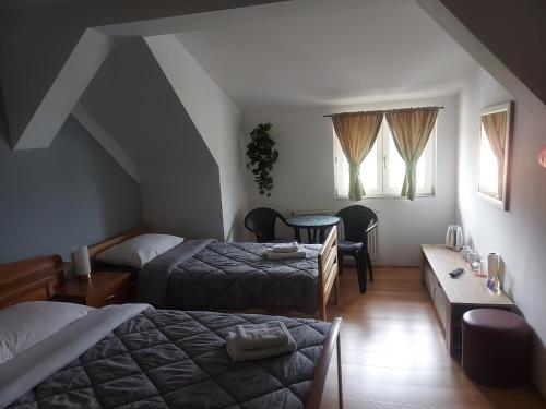 奧古林的住宿－內諾旅館，酒店客房设有两张床和一张桌子。