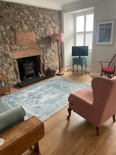 sala de estar con pared de piedra y chimenea en East Linton flat, sleeps 2, en East Linton