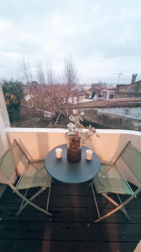 d'une table avec deux chaises et d'un vase avec des fleurs sur le balcon. dans l'établissement Balcon du Champ de Mars - #Parking #Air Conditioner #Clim, à Angoulême