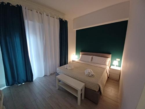 a bedroom with a large bed with a green wall at La Stazione 92 in Catania