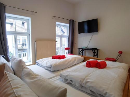 a room with two beds with red pillows on them at Domhotel in Sankt Wendel