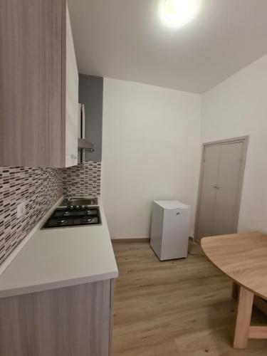 eine Küche mit einer weißen Arbeitsplatte und einem Tisch in der Unterkunft Flowers' Apartaments in Spoleto