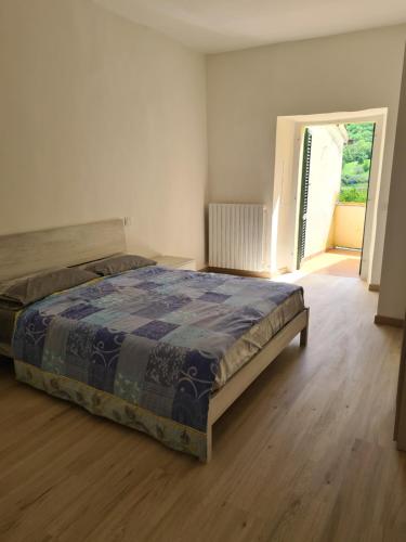 Schlafzimmer mit einem Bett und Holzboden in der Unterkunft Flowers' Apartaments in Spoleto