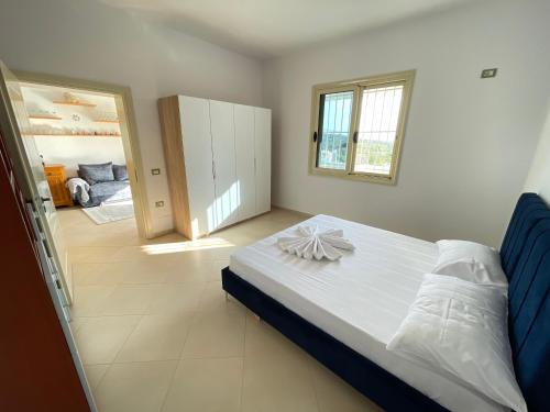 ein Schlafzimmer mit einem großen weißen Bett und einem Eingang in der Unterkunft Villa Gaia in Vlorë
