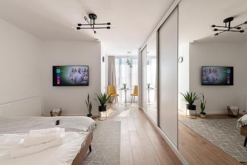 een witte slaapkamer met een bed en een groot raam bij Moon Apartments in Cluj-Napoca