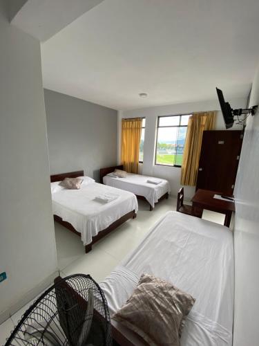 Habitación de hotel con 2 camas y ventana en Hospedaje Marbis, en Tarapoto