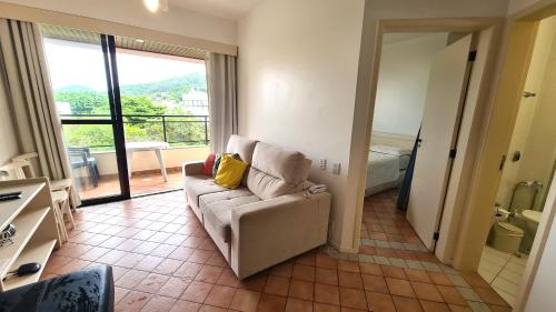 a living room with a couch and a balcony at Merit Plaza Standard - Beira Mar in Florianópolis