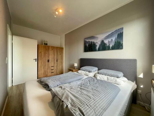 ein Schlafzimmer mit einem großen Bett und einem Gemälde an der Wand in der Unterkunft Ferienwohnung Bonny in Sankt Andreasberg