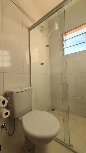 a bathroom with a toilet and a glass shower at Pousada São José in Guaratinguetá