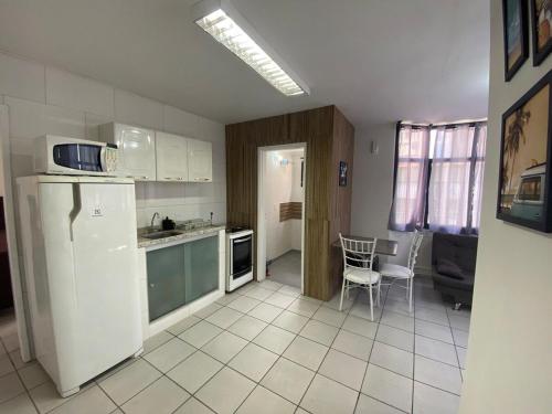 a kitchen with a refrigerator and a table and chairs at Apart 2 suítes Prox Cambuí Wi-Fi Gar Var Note Pet ap21 in Campinas