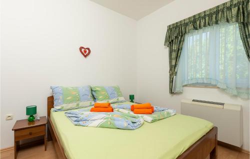 - une chambre avec un lit doté d'oreillers orange et une fenêtre dans l'établissement Beautiful Apartment In Pavicini With Wifi, à Pavicini