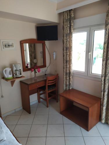 a bedroom with a desk and a mirror at Manos in Megás Limniónas