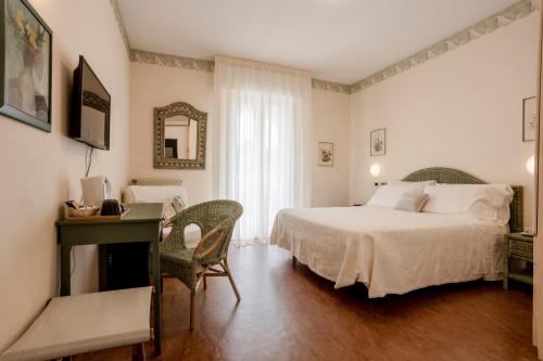 a bedroom with a bed and a desk with a computer at Villa Arizona in Milano Marittima