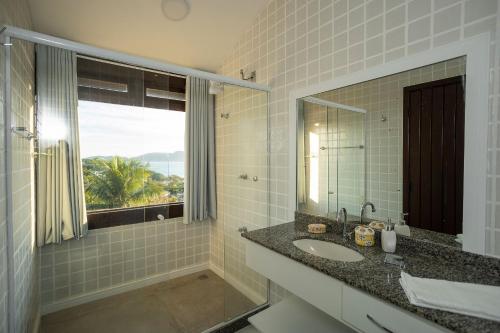 a bathroom with a sink and a mirror and a window at BZ20 Geribá com vista panorâmica! 6 quartos in Búzios