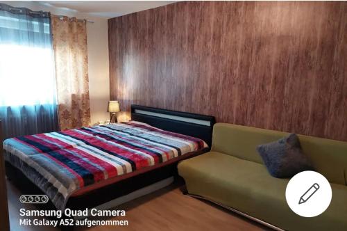 een slaapkamer met een bed en een bank bij Apartment mit 3 Zimmer in Wolfratshausen
