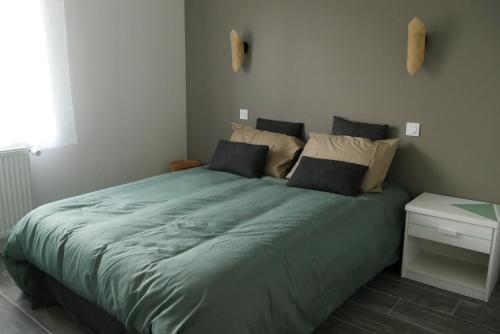 - une chambre avec un grand lit vert et une table de nuit dans l'établissement Logement à 100m du virage d'Arnage- Circuit des 24h du Mans - 6 personnes, à Arnage
