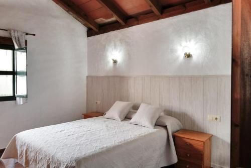 1 dormitorio con 1 cama blanca y 2 almohadas en Casa Juncal, en Tarifa