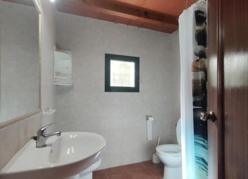 baño con lavabo y aseo y ventana en Casa Juncal, en Tarifa