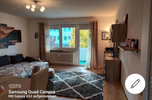 een woonkamer met een bank en een raam bij Apartment mit 3 Zimmer in Wolfratshausen