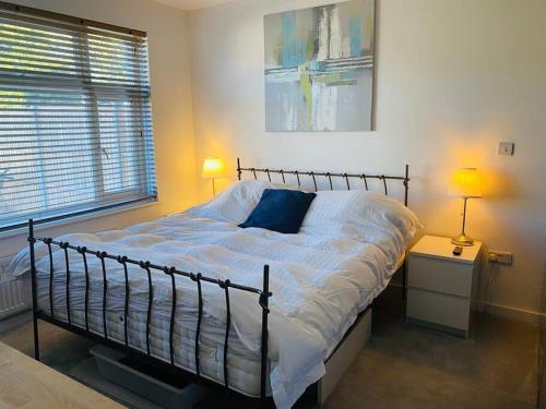 a bedroom with a large bed with white sheets at Love Lancing by the Sea with private Hot Tub sleeps 8 & plentiful free parking in Lancing
