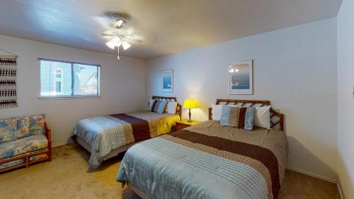 Un dormitorio con 2 camas y una silla. en LP10 Beach House on Stilts, Ocean View from Back Porch, Boardwalk, Outdoor Shower, en Port Aransas