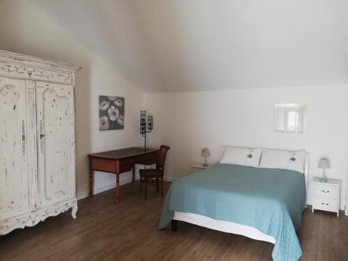 sypialnia z łóżkiem i biurkiem obok łóżka o wymiarach 6 x 6 w obiekcie LA MAISON D'ALIDA w mieście Nueil-sous-Faye