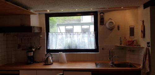 a kitchen with a window and a sink and a counter at Ferienhaus Neumühle in Lutzerath