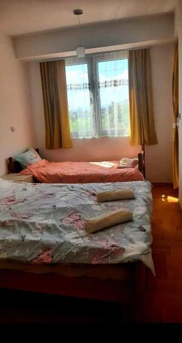 a bedroom with two beds and a window at Sunny Place in Ohrid