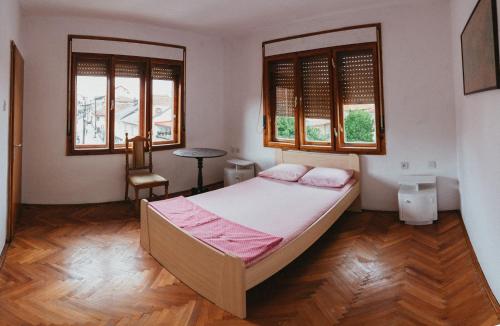 a bedroom with a bed and two windows at Sunset Lake hostel in Ohrid