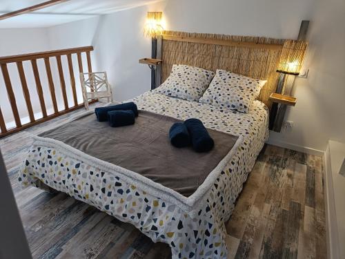 une chambre avec un grand lit avec des oreillers bleus dans l'établissement domaine de la pirouette, à Arvert