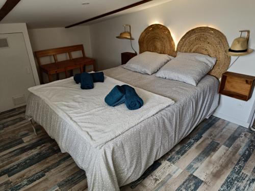 a bedroom with a large bed with two blue pillows at domaine de la pirouette in Arvert