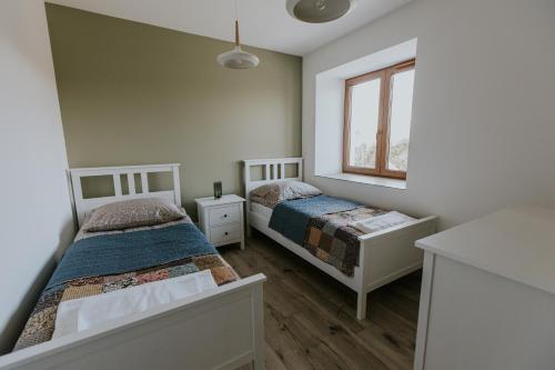 a bedroom with two beds and a window at Zapomniany Zdrój in Głuchołazy