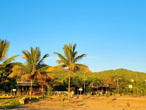 a resort with palm trees and a mountain in the background at CASITA MADAME in Puerto López